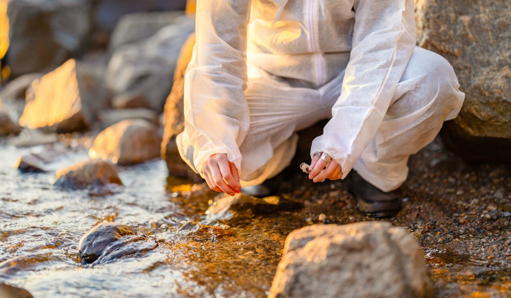 researcher collecting river rocks for tests